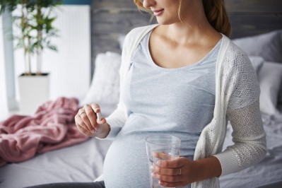 Pregnant woman taking iron supplements © GettyImages / gpointstudio